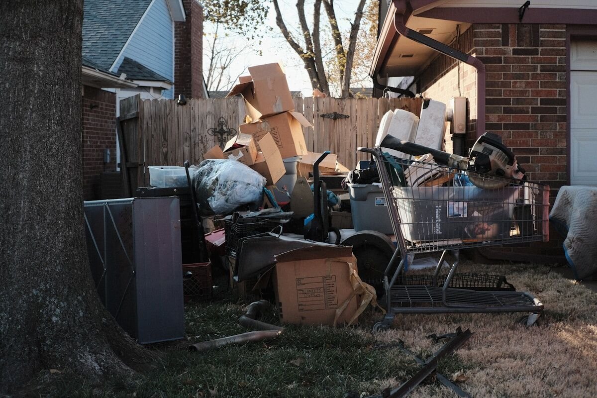 Pile of household junk and boxes beside a home, ready for junk removal